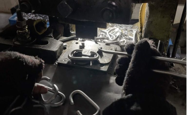 alt="Flattening both ends of bent, using precision stamping equipment during early-stage manufacturing">
